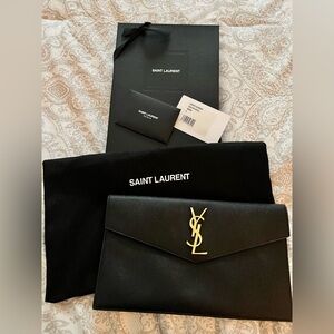 YSL black Uptown clutch with gold hardware.